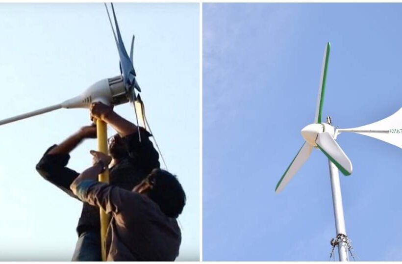 Dos personas instalando un generador eólico doméstico en un tejado.