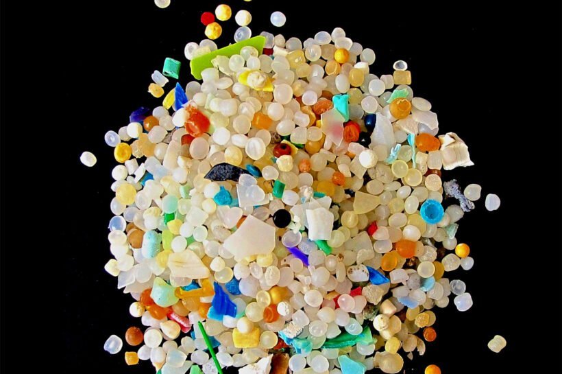 Trozos de plásticos de distintos colores sobre fondo negro.