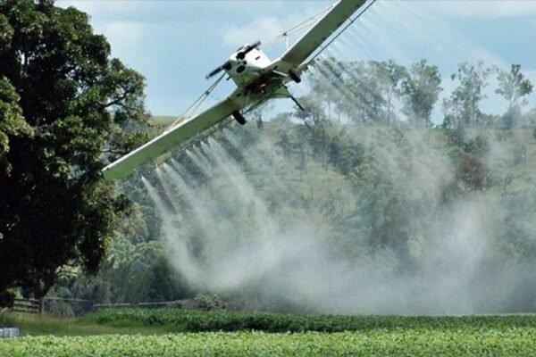Avión fumigando un campo de cultivo.