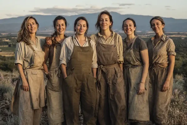 Grupo de mujeres rurales vestidas con ropas modernas de trabajo. en un paisaje de Castilla y León, representando el liderazgo de **FADEMUR León Día Mujer Rural**.
